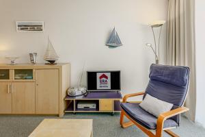 sala de estar con silla y TV en 't Pand C 0408 met parking Nieuwpoort, en Nieuwpoort