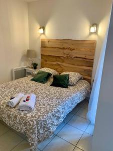 a bedroom with a bed with two towels on it at Le Café Crème jardin parking in Le Chambon-sur-Lignon