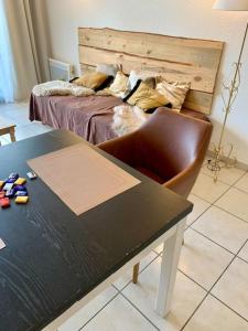 a bedroom with a bed and a table with a chair at Le Café Crème jardin parking in Le Chambon-sur-Lignon