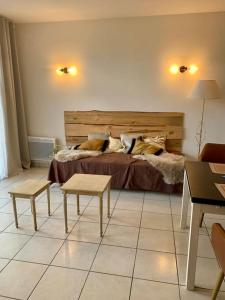 a bedroom with a bed and two tables in a room at Le Café Crème jardin parking in Le Chambon-sur-Lignon