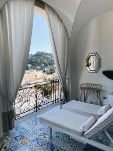 a bedroom with a balcony with two beds and a view at Capri Tiberio Palace - The Leading Hotels of the World in Capri +37 photos
