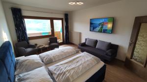 une chambre d'hôtel avec deux lits et un canapé dans l'établissement Pension zum Mühlrad, à Millstatt