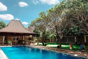 a swimming pool in front of a house at Tirtodipuran Hotel Yogyakarta in Timuran