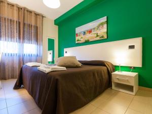 Dormitorio verde con cama y pared verde en Al Molì Affittacamere, en Cagliari