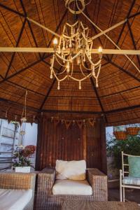 a chandelier is hanging from a straw tent with a chair at Mirabel Guesthouse in Parys