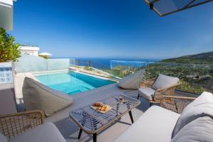 patio ze stołem i krzesłami oraz basenem w obiekcie Inorato - Luxury Villa with Private Swimming Pool w mieście Kalamitsi