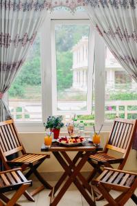 峰牙的住宿－豐芽塔帕酒店，窗前的一张桌子和两把椅子