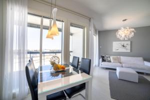 uma sala de estar com uma mesa de jantar e um sofá em Meritähti Apartments by Hiekka Booking em Kalajoki