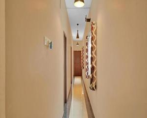a hallway with a long corridor with a wall with aacoustic at FabExpress Joel Inn in Chennai
