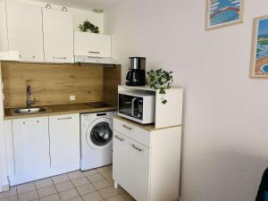 eine Küche mit einer Mikrowelle und einer Waschmaschine in der Unterkunft Appartement Saint-Aygulf, 1 pièce, 4 personnes - FR-1-226A-155 in Fréjus