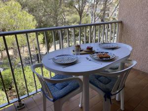 einen weißen Tisch mit Tellern aus Essen auf einem Balkon in der Unterkunft Appartement Saint-Aygulf, 1 pièce, 4 personnes - FR-1-226A-155 in Fréjus