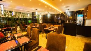 a restaurant with tables and chairs and a bar at Tranquila Hotels and Suites Abuja in Abuja