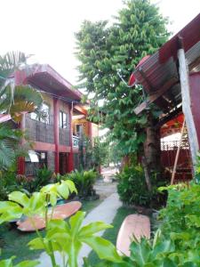 a courtyard of a house with a tree and a building at Nine Clouds Homestyle Accommodation in General Luna