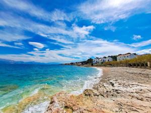 a beach with the ocean and houses in the background at Apartment Renata in Sutivan
