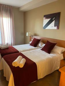Pomar的住宿－EL RINCON DE TOÑO，两间相邻的床铺位于酒店客房内