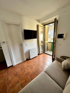 un soggiorno con divano e pavimento piastrellato di Casa Cibrario - vicino Porta Susa F.S. a Torino