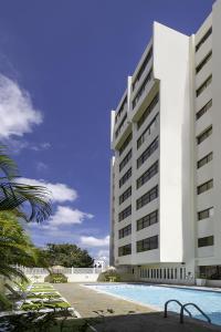 a large white building with a swimming pool in front of it at Radisson Hotel Santo Domingo in Santo Domingo