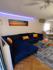 a blue couch in a living room with yellow pillows at Apartment Sunrise in Dugi Rat