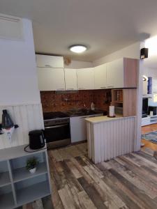 a kitchen with white cabinets and a wooden floor at Apartment Sunrise in Dugi Rat