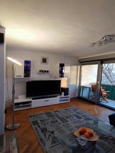 a living room with a flat screen tv and a table at Apartment Sunrise in Dugi Rat