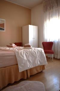 Pradamano的住宿－Meridiana 1，一间卧室配有一张床和一张红色椅子