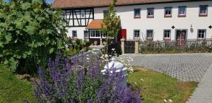 a garden with purple flowers in front of a building at Hossies Hof - Elke in Bertsdorf