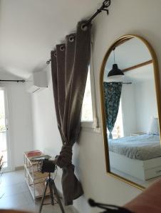 a mirror in a room with a bed and a camera at Maison 38m2 15min de Corte 30min de Bastia in Bigorno