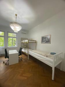 a bedroom with a bed and a desk and a chandelier at Rooms Miklošičeva in Ljubljana