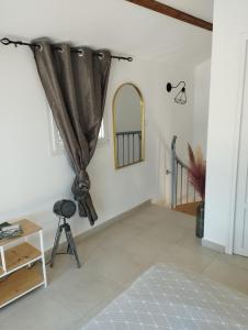 a room with a curtain and a table and a mirror at Maison 38m2 15min de Corte 30min de Bastia in Bigorno