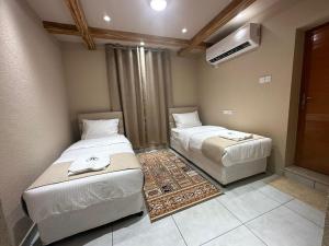 a bedroom with two beds and a air conditioner at Al Hamra Mountain View in Al Ḩamrāʼ