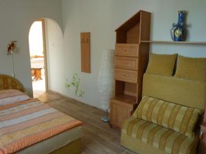 ein Schlafzimmer mit einem Bett, einer Kommode und einem Stuhl in der Unterkunft Penzion Čech in Valtice