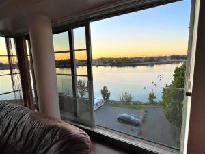 a room with a large window with a view of a lake at Ringi 37 Riverview Holiday Apartments in Pärnu +13 photos
