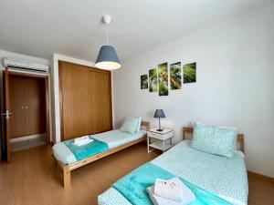 a small room with two beds and a lamp at Alcantarilha Vilalux by Homing in Alcantarilha
