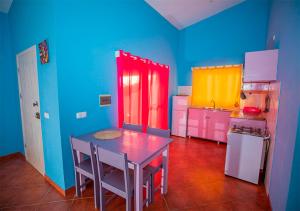 uma cozinha com paredes coloridas, uma mesa e um frigorífico em Villa Lagosta Stella Maris Exclusive na Vila do Maio