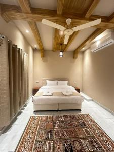 1 dormitorio con cama y alfombra en Al Hamra Mountain View, en Al Ḩamrāʼ