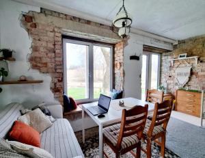 uma sala de estar com uma mesa com um computador portátil em Gluosnių vila - Adutiškio pirtis em Švenčionys