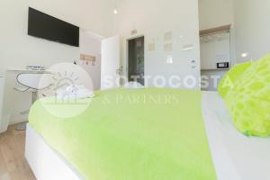 una cucina bianca con piano di lavoro verde in una stanza di L'Ormeggio a Porto Cesareo