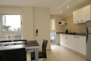 a kitchen with white cabinets and a table at Departamentos Nubes - Salta Capital in Salta