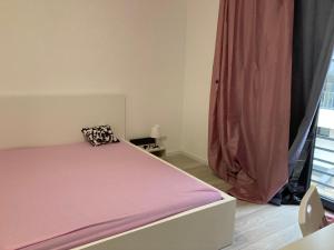 - une chambre avec un lit avec des draps roses et une fenêtre dans l'établissement JoyGate entire villa, à Otopeni