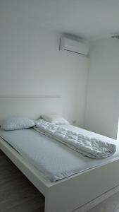 a white bed in a room with a white wall at JoyGate entire villa in Otopeni +56 photos