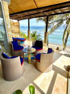 d'une terrasse avec des chaises et une table et la plage. dans l'établissement Ocean Suite - Exceptional Beachfront Apartment - Candidasa, à Candidasa