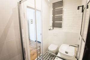 ein weißes Bad mit einem WC und einem Waschbecken in der Unterkunft Apartament Eliza - 2 Bathrooms! Best View Ever in Toruń