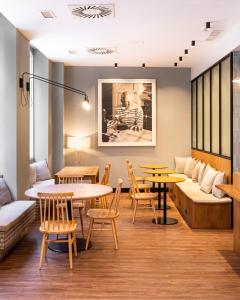 una stanza con tavoli, sedie e un divano di TOC Hostel Malaga a Málaga