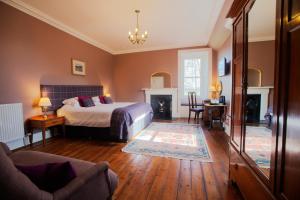 a bedroom with a bed and a living room at Cardhu Country House in Aberlour