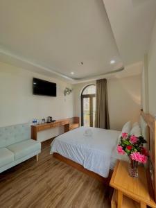 een slaapkamer met een bed, een bank en een tv bij SK BOUTIQUE HOTEL in Phu Quoc +33 foto's