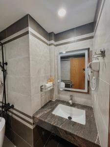 een badkamer met een wastafel en een spiegel bij SK BOUTIQUE HOTEL in Phu Quoc