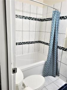 a bathroom with a white tub and a toilet at Cozy 4 bedroom townhouse - peaceful feel of home in Winnipeg