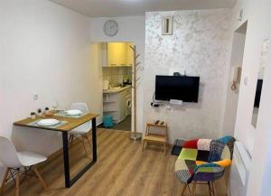 Una sala de estar con una mesa y sillas y un televisor. en Cozy & fully equipped studio in the heart of downtown and next to Kalemegdan, en Belgrado