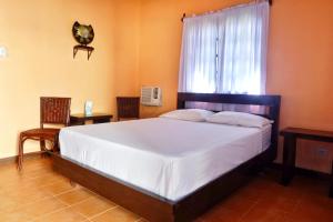 a bedroom with a large bed and a window at Puesta del sol Beach Bungalows and Restobar in Abu