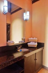 ein Badezimmer mit einem Waschbecken und einem großen Spiegel in der Unterkunft Puesta del sol Beach Bungalows and Restobar in Abu
